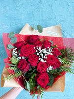 One dozen red roses with green and baby's breath.