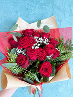 One dozen red roses with green and baby's breath.